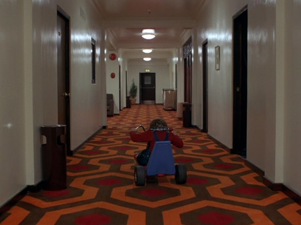 The Shining - Danny keeps his head down as he cycles past the open door